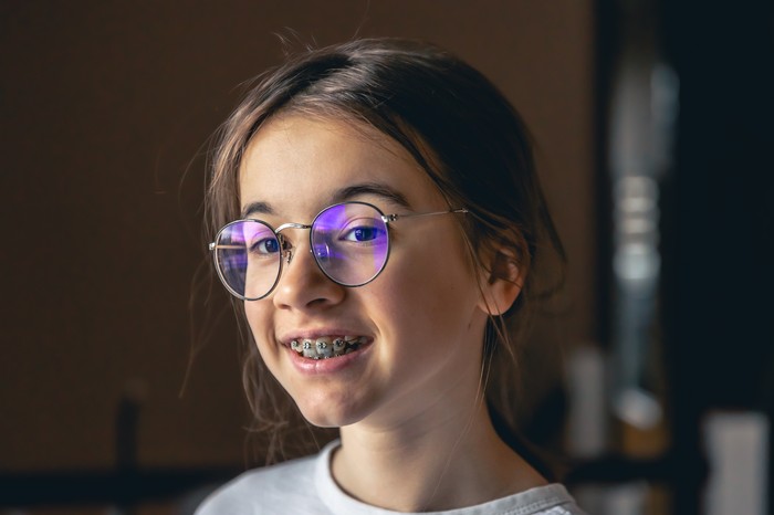 portrait-d-une-adolescente-avec-des-lunettes-et-des-appareils-orthopediques