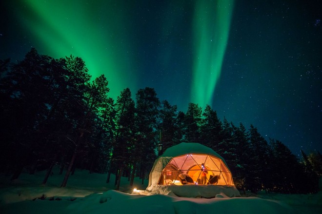 northern lights at night in lapland above a glass igloo