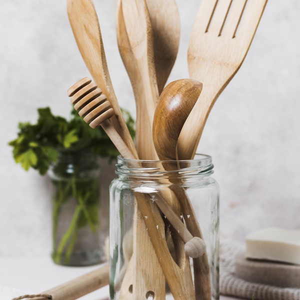 tarro de cristal que contiene utensilios de madera
